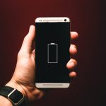 person holding low battery smartphone