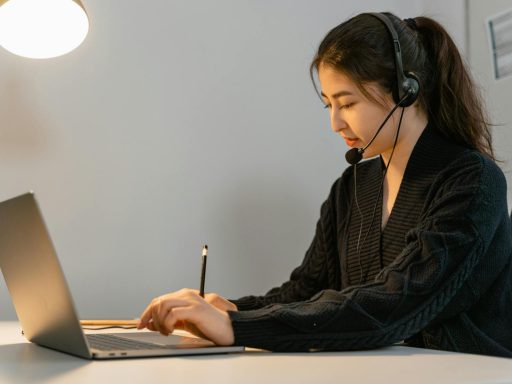 Focused call center agent working on a laptop with headphones. Customer service professional in an office setting.