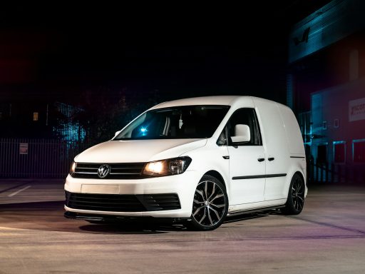 a white van parked in a parking lot at night