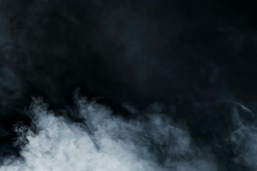 Ethereal white smoke on a black background creates a sense of mystery and depth.