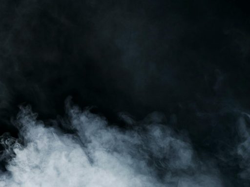 Ethereal white smoke on a black background creates a sense of mystery and depth.