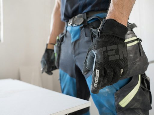 a man wearing a pair of black and blue work gloves