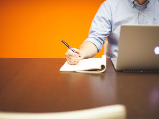 Ondernemer die zijn missie en visie opschrijft in een notitieboek aan een bureau