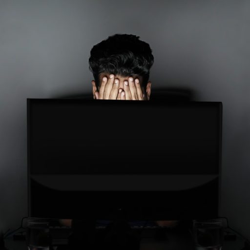 Ondernemer achter laptop met papieren documenten voor subsidieaanvraag