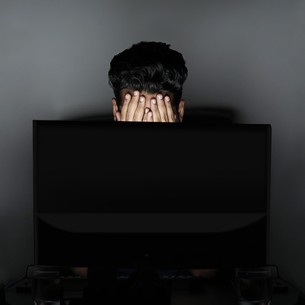 Ondernemer achter laptop met papieren documenten voor subsidieaanvraag
