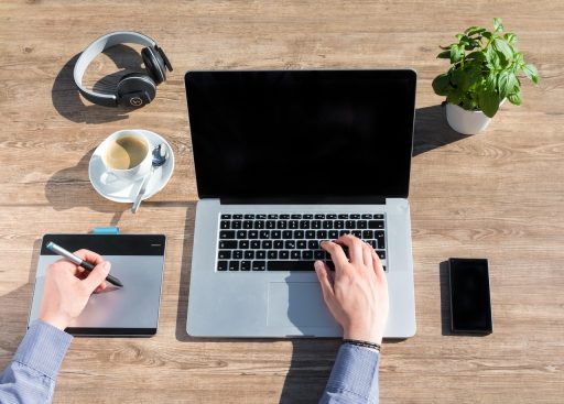 Freelancer werkt achter laptop aan huis en bekijkt financiële documenten