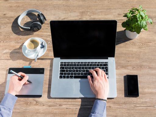 Freelancer werkt achter laptop aan huis en bekijkt financiële documenten