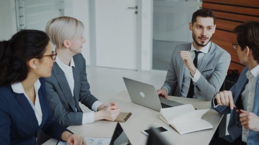 Four professionals in a business meeting around a table