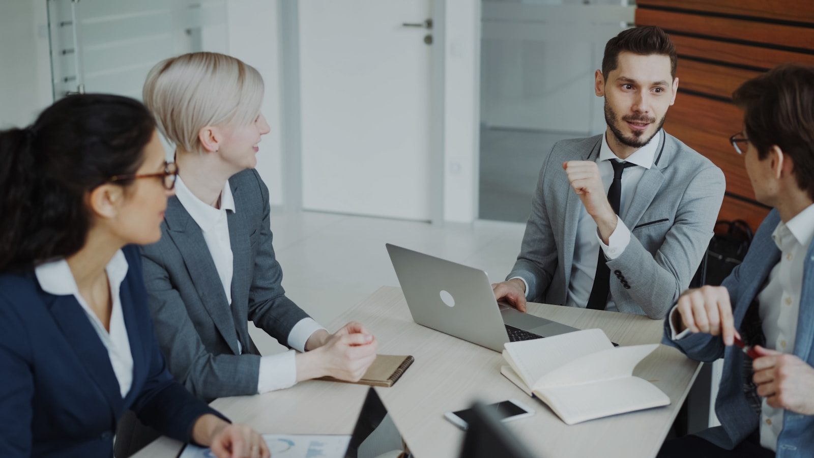 Four professionals in a business meeting around a table