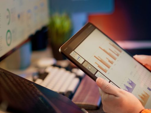 Someone analyzes financial data on a tablet.