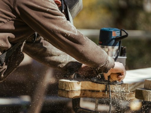 a man sanding a piece of wood with a sander