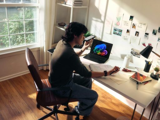 Person working at a desk with a laptop and books.