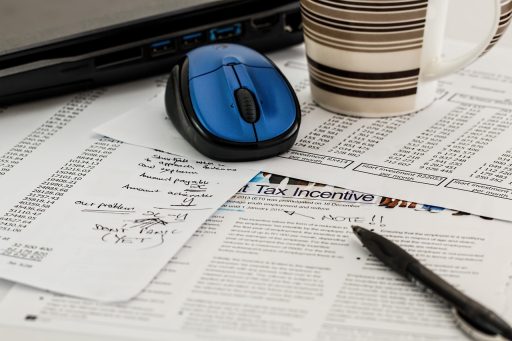 Ondernemer die btw-documenten en financiële overzichten doorneemt aan bureau