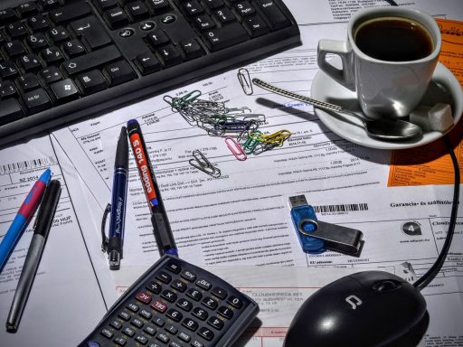 Ondernemer die een factuur opstelt op zijn bureau met papieren en laptop