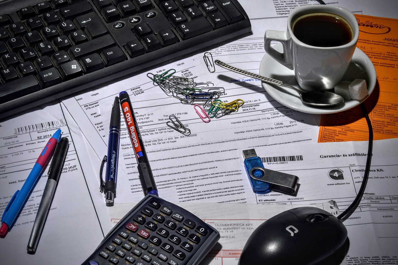 Ondernemer die een factuur opstelt op zijn bureau met papieren en laptop