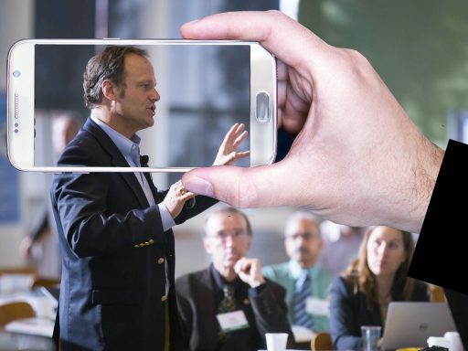 Een man spreekt zelfverzekerd voor een publiek op een zakelijk podium